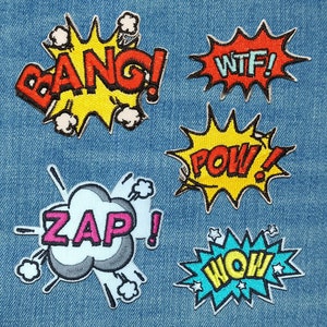 May include: Six colorful embroidered iron-on patches with comic book style sound effects: "Bang!" in yellow and red, "WTF!" in red, "Pow!" in yellow and red, "Zap!" in pink and gray, "Wow!" in blue and yellow.