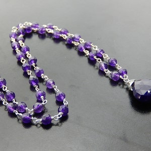 Puede incluir: Un collar de cadena de plata con un colgante de amatista en forma de l&aacute;grima. El collar est&aacute; hecho con peque&ntilde;as cuentas de amatista y una cadena de plata.