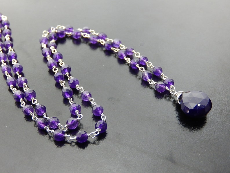 Puede incluir: Un collar de cadena de plata con un colgante de amatista en forma de l&aacute;grima. El collar est&aacute; hecho con peque&ntilde;as cuentas de amatista y una cadena de plata.