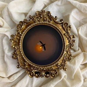 May include: A round painting of a firefly in a dark setting, framed by an ornate gold-coloured frame. The firefly is silhouetted against a warm, glowing light. The frame has intricate scrollwork and a vintage aesthetic. The text "TuanArt Studio" is visible at the bottom.