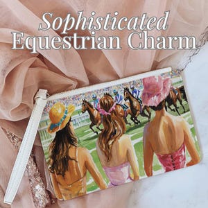 Könnte beinhalten: Weiße Clutch-Tasche mit einer farbenfrohen Illustration von drei Frauen, die ein Pferderennen beobachten. Die Frauen tragen Hüte und Kleider. Der Hintergrund ist ein grünes Feld mit einer Menschenmenge in der Ferne.