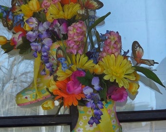 características para colgar en la puerta Botas de lluvia. Las botas están adornadas con una variedad de coloridas flores primaverales.