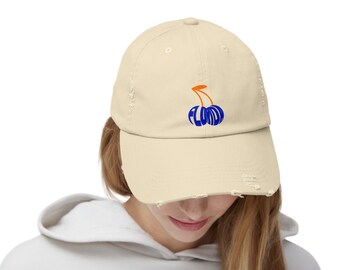 Könnte beinhalten: Eine abgenutzte, beige Baseballkappe mit einem blauen und orangenen Kirschendesign. Die Kirsche besteht aus dem Wort "FLUMMO"