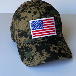 May include: A camouflage baseball cap with a small American flag patch on the front.