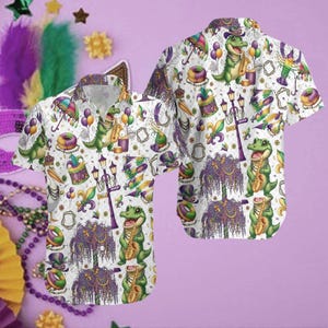 Peut inclure: Chemise blanche à manches courtes avec un motif répété d'alligators verts jouant du saxophone, de perles du Mardi Gras et d'autres éléments festifs. La chemise a un col, idéale pour un look décontracté et festif.