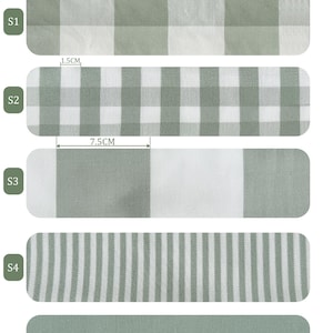 Pu&ograve; includere: Campioni di tessuto in verde grigiastro, che mostrano diversi motivi. I campioni includono disegni a quadri, a righe e a tinta unita. Le misure in centimetri sono visualizzate sopra alcuni motivi.