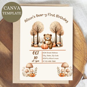 Puede incluir: Tarjeta de invitación beige con el texto "Alison's Bear-y First Birthday". La tarjeta presenta una ilustración de acuarela de un oso de peluche, calabazas y árboles. La fecha es el 10 de octubre a las 3 pm.
