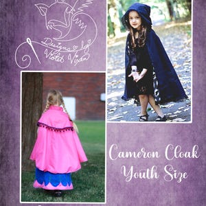 May include: A pink and blue hooded cloak with a white trim and pom-poms. The cloak is worn by a child standing on a green lawn. The text "Cameron Cloak Youth Size" is written in white on a purple background. The text "Designs by Violet Vixen" is written in white on a purple background.