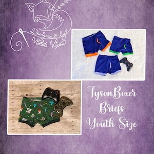 Könnte beinhalten: Boxershorts für Jugendliche in Blau und Grün, mit einem Videospiel-Controller. Das Bild enthält den Text "Tyson Boxer Briefs Youth Size" und den Markennamen "Designs by Violet Vixen".