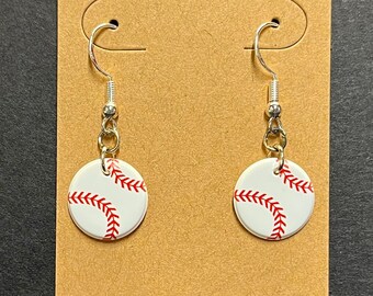 May include: A pair of silver baseball earrings with white and red baseballs hanging from silver hooks.