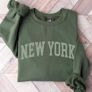 May include: A green sweatshirt with the text "NEW YORK" in white letters.
