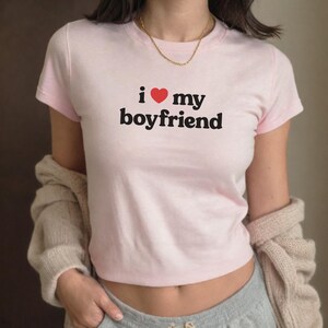 May include: A pink t-shirt with the text "i &hearts; my boyfriend" printed on the front.