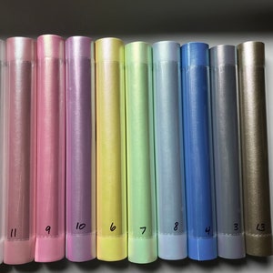May include: A set of 10 iridescent vinyl rolls in various colors, including white, pink, lavender, yellow, green, blue, and gold. The rolls are numbered 15, 11, 9, 10, 6, 7, 8, 4, 3, and 13.
