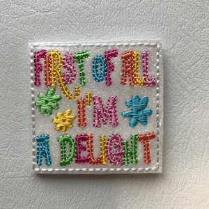 May include: A white patch with colorful embroidered text that reads "First of all I'm a delight".