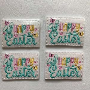 May include: Four embroidered patches with the words "HAPPY EASTER" in teal, pink, and yellow. Each patch has a butterfly and bunny ears design. The patches are rectangular with a white background and a stitched border.