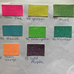 May include: A collection of 10 small squares of glitter paper in various colors, including neon pink, yellow, mint, azure, neon green, mintish, neon orange, and light purple. Each square is labeled with a number and a color name.