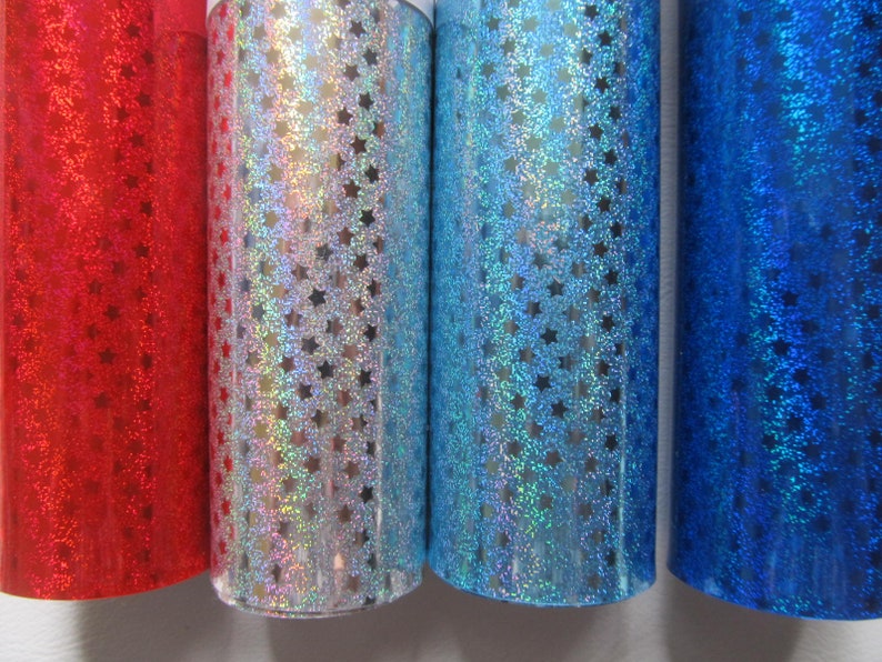 May include: Four rolls of iridescent vinyl with a star pattern. The rolls are red, silver, blue, and dark blue.