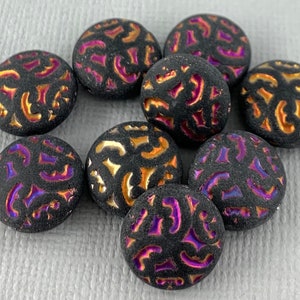 May include: Nine black glass beads with a raised pattern of swirls and lines in gold and purple iridescent colors.