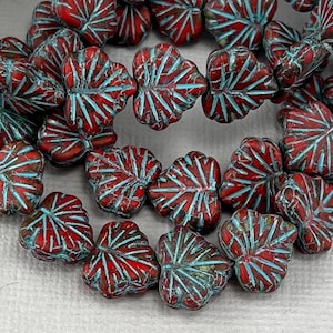 May include: Red and blue glass beads in the shape of leaves. The beads have a textured surface and are strung together.