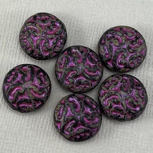May include: Six round, flat, purple and black glass beads with a swirling, embossed pattern.