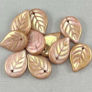 May include: A collection of iridescent leaf-shaped beads in shades of peach and gold. Each bead features a detailed leaf vein design and a small hole for stringing. These decorative beads are ideal for jewelry making and craft projects.