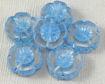May include: Six light blue glass flower-shaped buttons with a raised center design.