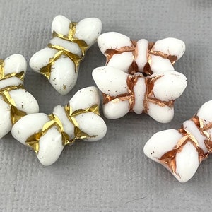 May include: White glass butterfly beads with gold and copper accents. The beads are about 1 inch in size and have a delicate, intricate design.