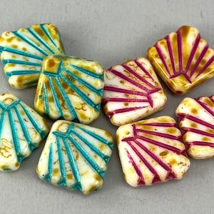 May include: Assortment of white ceramic square beads with a fan-shaped design. Some beads have turquoise accents, while others have pink accents.