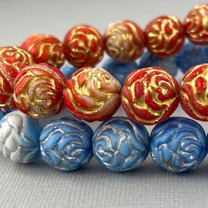 May include: Two strands of beads, one red with gold accents and one blue with silver accents, both featuring a rose design.