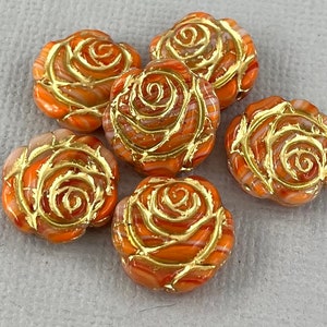 May include: Six orange glass rose beads with gold accents. The beads are approximately 1 inch in diameter and have a swirl pattern.