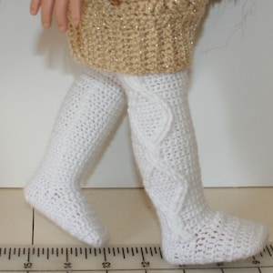 May include: White crocheted doll tights with a cable knit pattern.