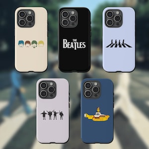 May include: Six different phone cases featuring The Beatles. The cases are black, white, light blue, and light purple. The designs include the Beatles logo, the band members' faces, the band crossing Abbey Road, and the Yellow Submarine.