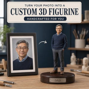 Puede incluir: Una figura 3D personalizada de un hombre con suéter azul marino, camisa azul claro y pantalones grises, sobre una base de madera oscura con una placa metálica que dice DAD. Una foto enmarcada del mismo hombre se muestra al lado.