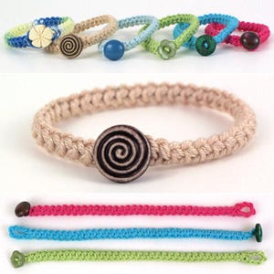 Può includere: Braccialetti all'uncinetto fatti a mano in vari colori, tra cui blu, rosa, verde e beige. Ogni braccialetto presenta un'esclusiva chiusura con bottone, con design a spirale, a fiore e rotondi. Circonferenza di circa 18 cm.