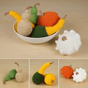 May include: A collection of crocheted gourds and a prickly pear in a white bowl. The gourds are in various shades of green, yellow, and beige. The prickly pear is white with a brown spot.