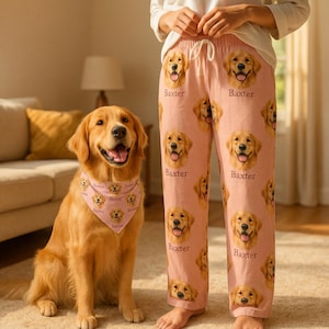 Könnte beinhalten: Hellrosa Schlafanzughose mit einem sich wiederholenden Muster aus dem Gesicht eines Golden Retrievers und dem Namen "Baxter". Ein passendes Halstuch wird von einem Golden Retriever-Hund getragen. Der Hund sitzt auf einem beigen Teppich.