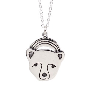 May include: Silver necklace with a polar bear pendant and a rainbow arch above its head.