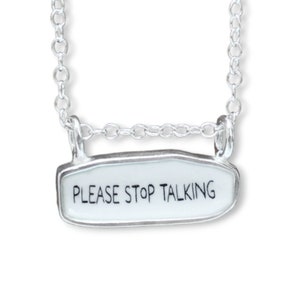 May include: A silver chain necklace with a silver pendant that says "PLEASE STOP TALKING".