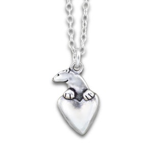 May include: A silver necklace with a heart-shaped pendant featuring a polar bear figurine. The bear is perched on the heart, with its paws resting on the edge.