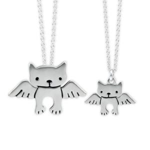Puede incluir: Dos collares de plata con un colgante de gato con alas. El colgante m&aacute;s grande est&aacute; en una cadena m&aacute;s larga y el colgante m&aacute;s peque&ntilde;o est&aacute; en una cadena m&aacute;s corta.