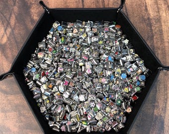 May include: A large collection of silver-toned modular link charms featuring various colorful enamel designs, symbols, and patterns, all contained within a black hexagonal tray with snap-button corners for storage and organization.