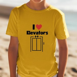 May include: A yellow t-shirt with a black graphic that says "I love Elevators" with a red heart and a black silhouette of a lift.