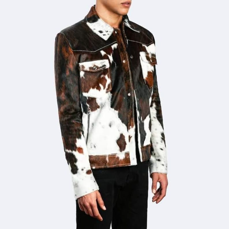 May include: A brown and white cowhide jacket with a button-up front and a zipped pocket on the left side.