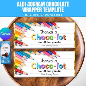 Puede incluir: Dos envoltorios de barras de chocolate con el texto "Thanks a Choco-lot" y lápices de colores. Los envoltorios están sobre una bandeja de madera, con una pequeña barra de chocolate y un logotipo de Canva en la esquina. El texto "ALDI 40GRAM CHOCOLATE WRAPPER TEMPLATE" está en la parte superior.