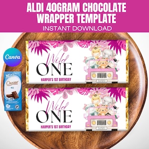 May include: Two pink and white chocolate bar wrappers with a jungle animal theme. The wrappers feature a pink jeep with animals inside and the text "Wild One" and "Harper's 1st Birthday".