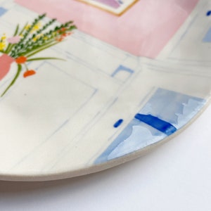 A closeup shot of a colorful hand-painted illustration plate by Lisa Rupp.