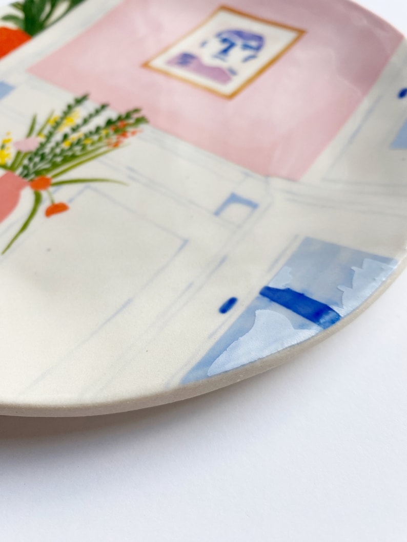 A closeup shot of a colorful hand-painted illustration plate by Lisa Rupp.