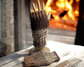 May include: A pair of brown and beige fingerless gloves with a textured knit pattern. The gloves are displayed on a wooden surface.