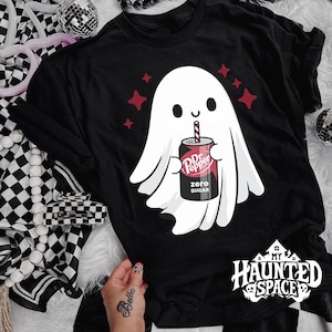May include: Black t-shirt featuring a white ghost holding a Dr. Pepper Zero Sugar can with a red and white straw. The ghost is surrounded by red star shapes. The text "My Haunted Space" is at the bottom.