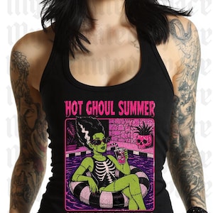 May include: Black tank top with a graphic featuring a green monster in a pool float, sunglasses, and the text "HOT GHOUL SUMMER". The design includes a skull and the phrase "NO MELTDOWNS. JUST MAKEUP, MONSTERS & MAYHEM."